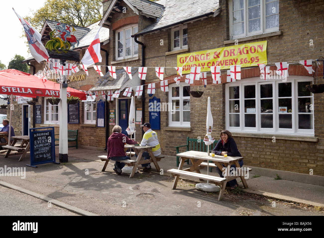 Menschen trinken Bier außerhalb der George und Dragon Pub auf St Georges Tag, Snailwell, Cambridgeshire UK Stockfoto