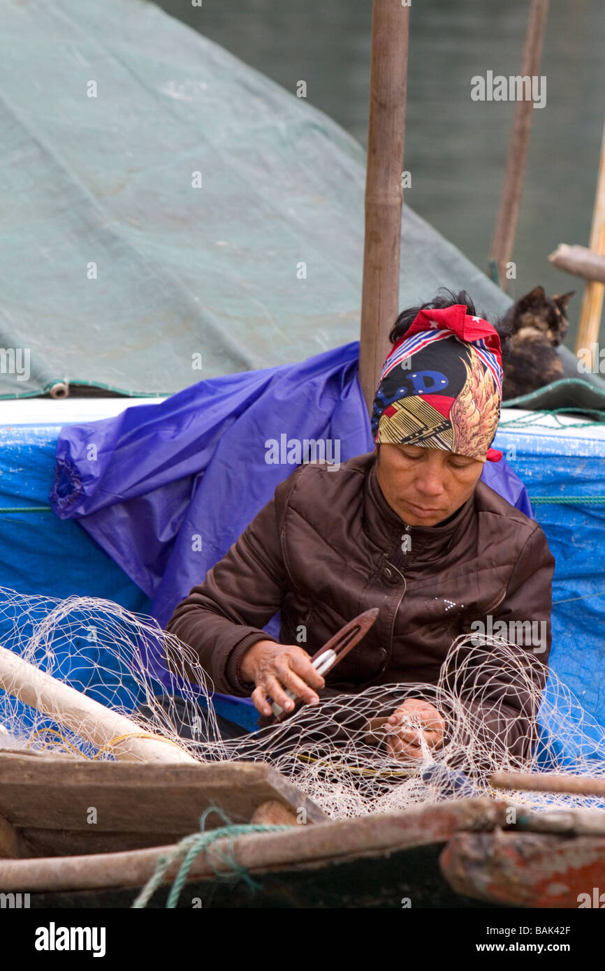 Vietnamesische Mann Reparatur Fischernetze in Ha Long Bay Vietnam Stockfoto