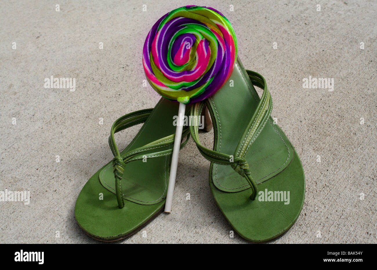 Grün Flip-Flop Fersen mit einem bunten Lutscher Stockfoto