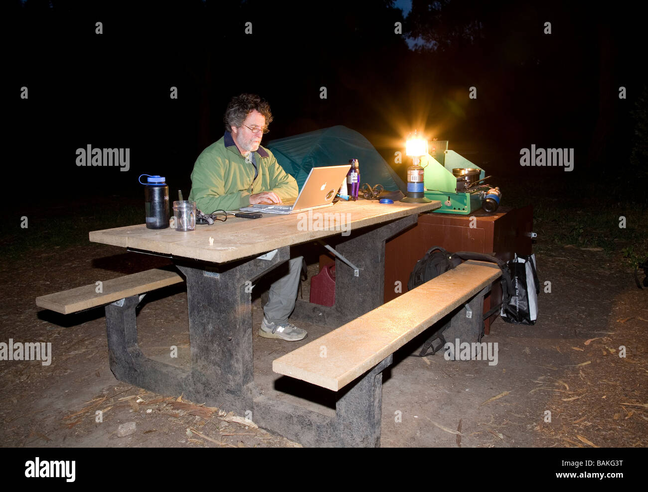 Mann mit Hilfe eines Computers beim camping, Insel Santa Cruz, Channel Islands Nationalpark, Kalifornien Stockfoto