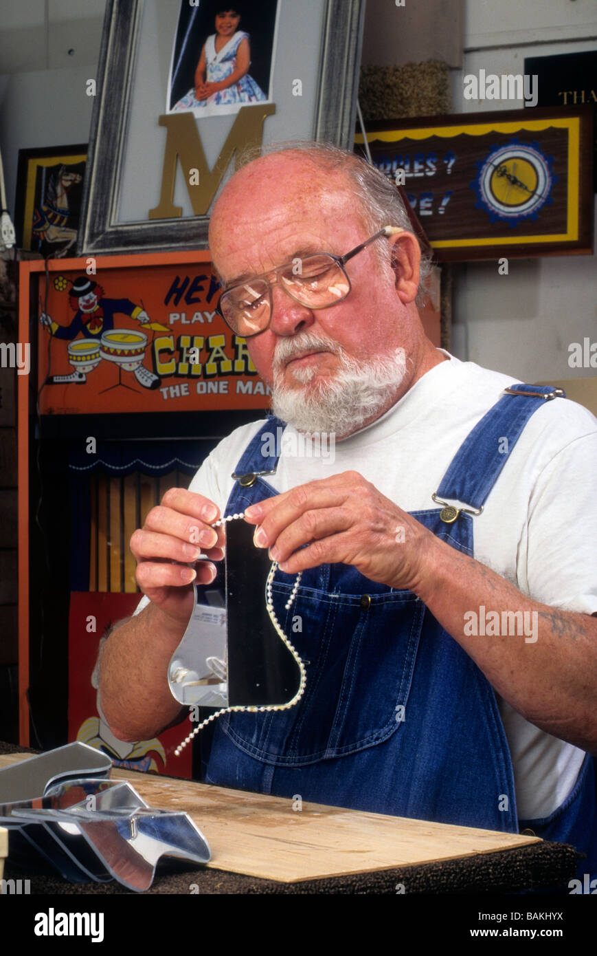 Senior Charlie Scholl Bart Arbeit Handwerk zu schaffen Modell Karussell Spielzeug Spaß Farbe Farbe Hobby Präzision Pflege Absicht genießen Pferd Stockfoto