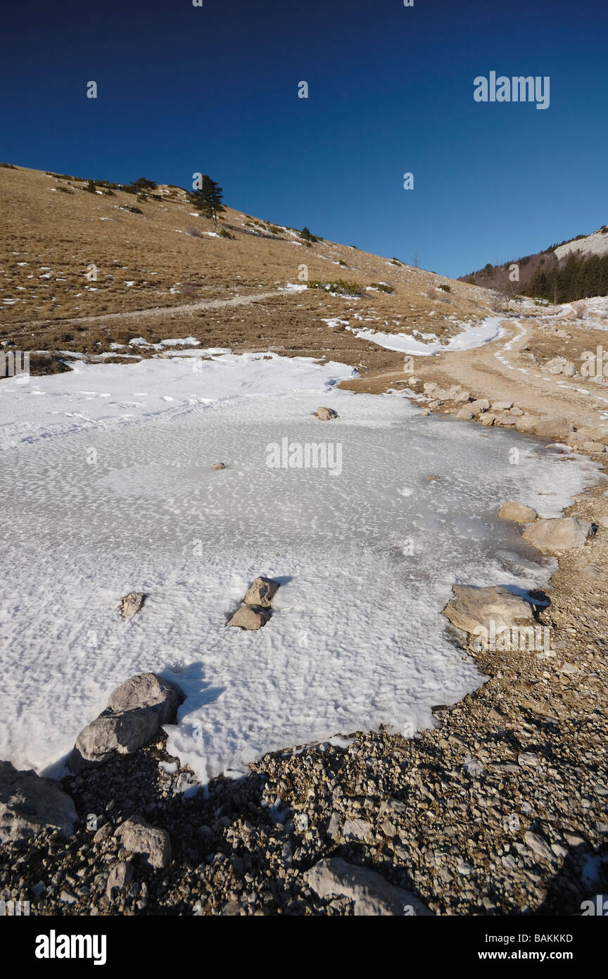 Gefrorene Pfütze in einem Berg bei hellen, sonnigen Tag Stockfoto