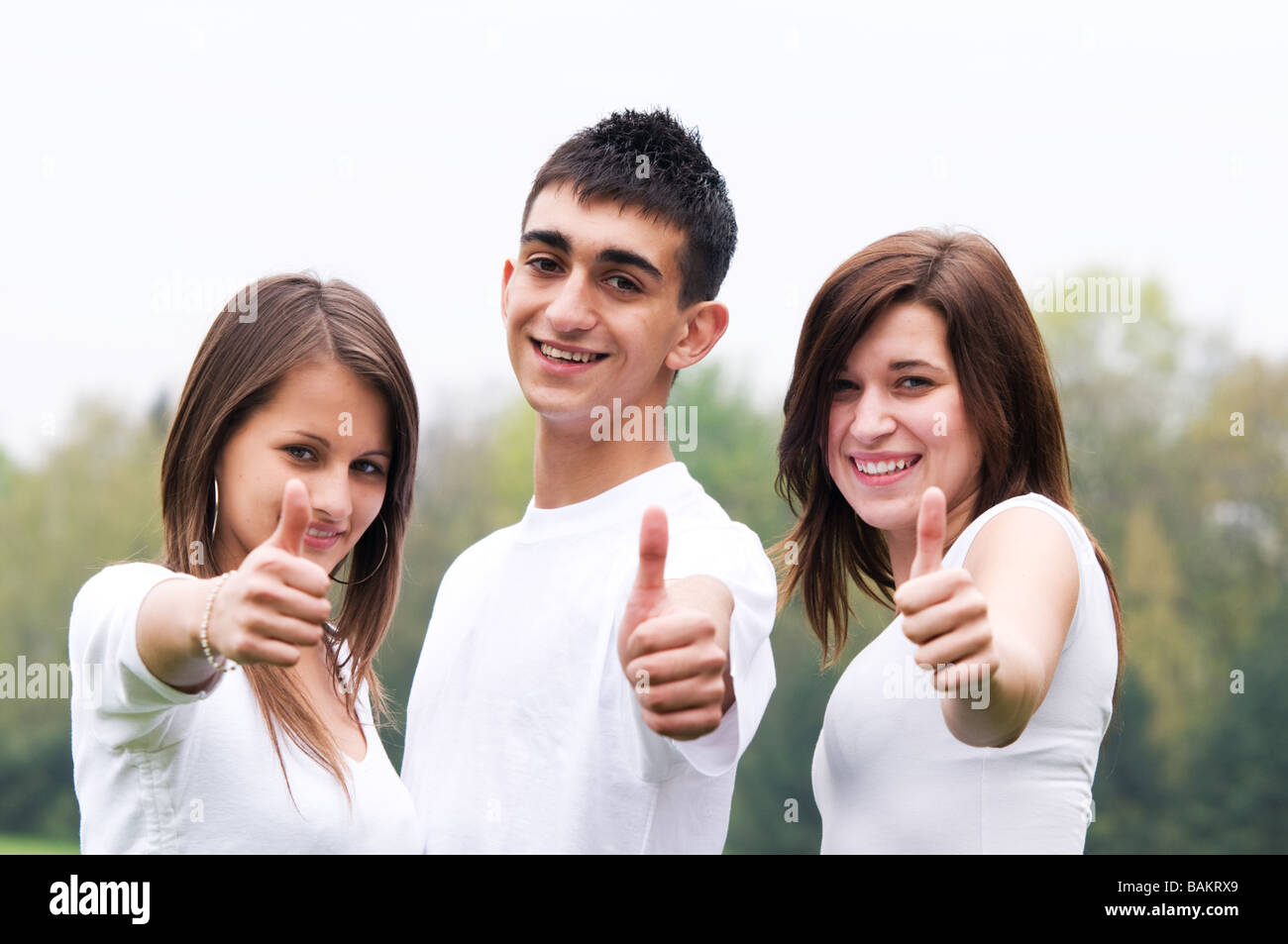 Drei junge glückliche Freunde lachen und er Ordnung Zeichen Stockfoto