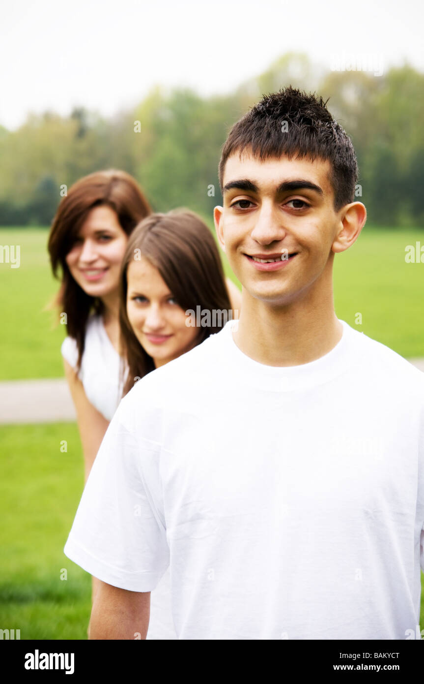 Gruppe von Jugendlichen stehen und Lächeln auf den Lippen. Junge im Vordergrund Stockfoto