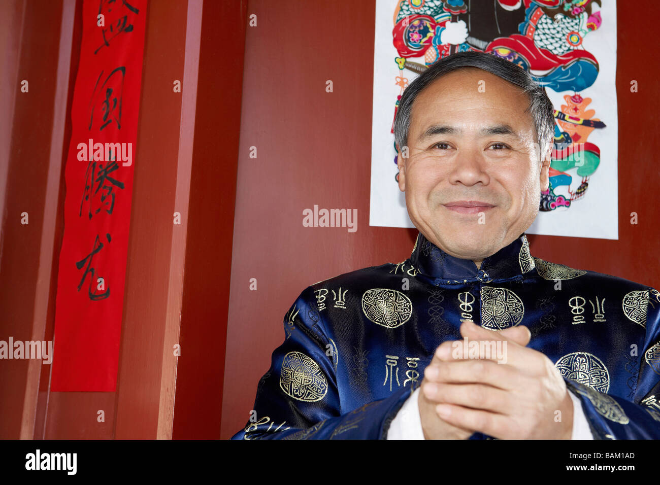 Traditionell gekleideter älterer Mann mit seinen Händen umklammert Stockfoto