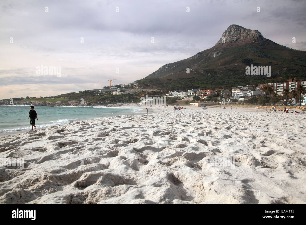 Junge zu Fuß entlang der Brandung am Strand von Camps Bay, Cape Town, Südafrika Stockfoto