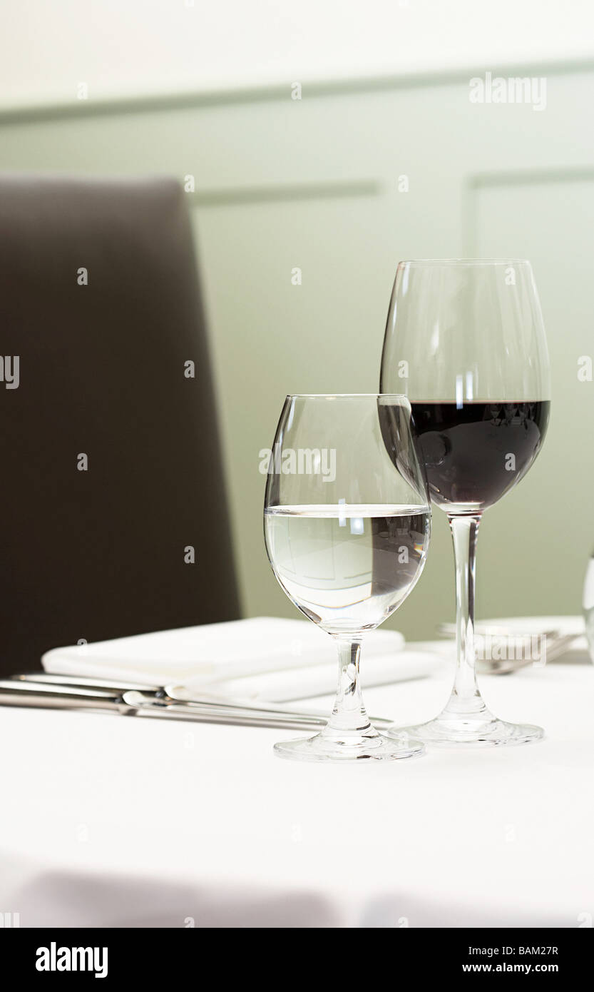 Ein Glas Wasser und Rotwein auf einem Tisch Stockfoto