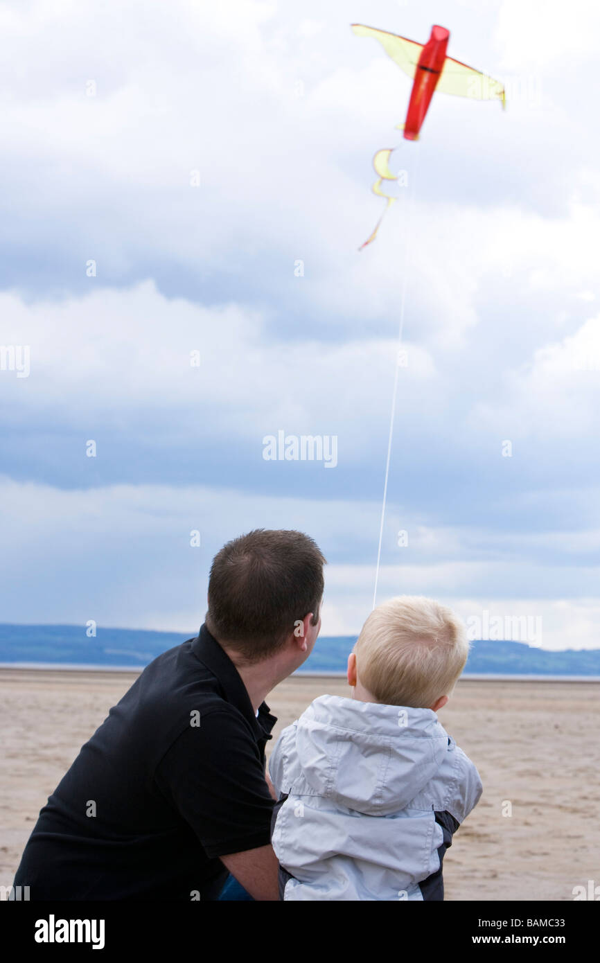 Vater und Sohn einen Drachen am Strand Stockfoto