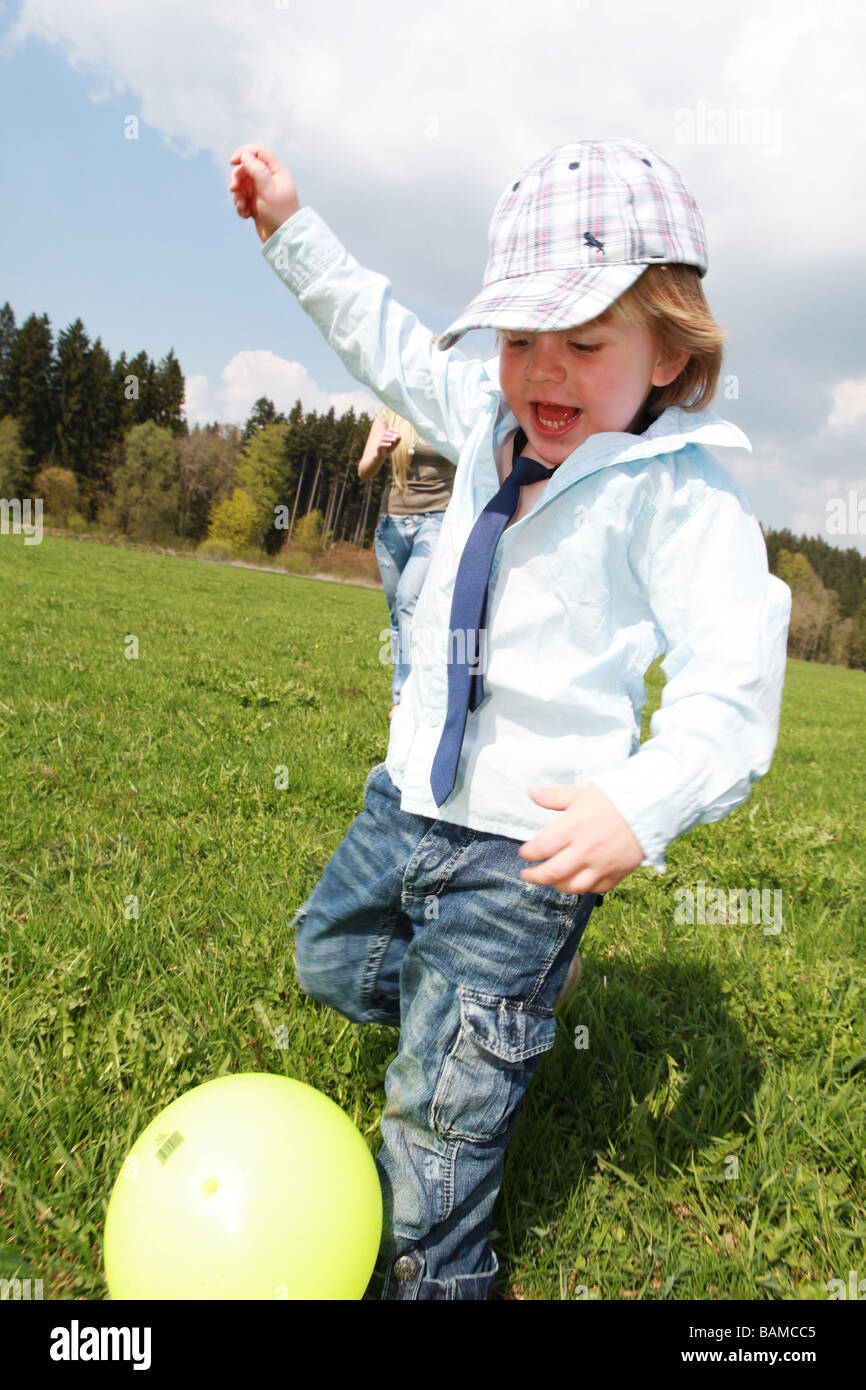 junge zwei Jahre in Folge auf der Wiese Stockfoto