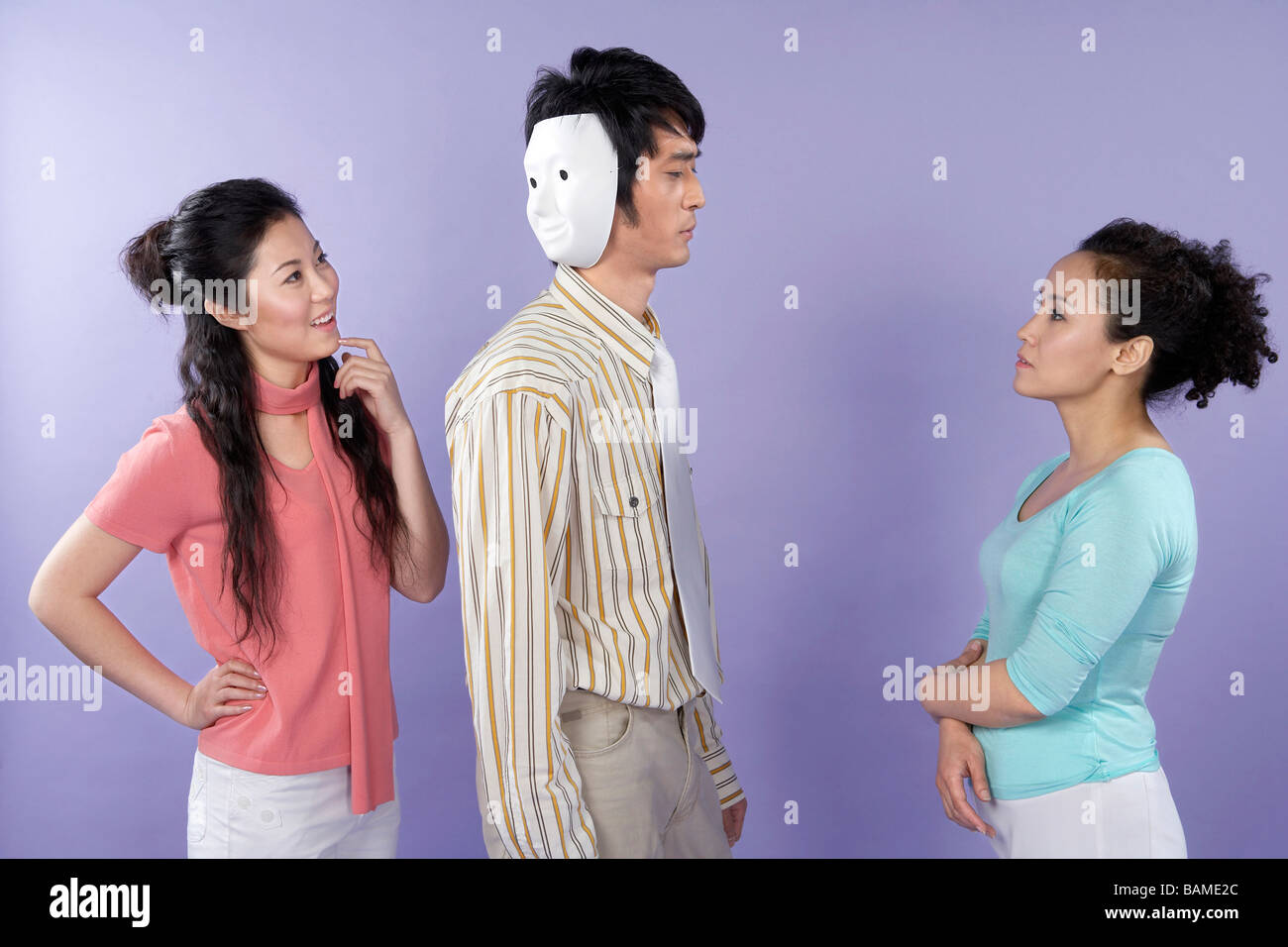 Junge Frauen im Gespräch mit einem Two-faced Mann Stockfoto