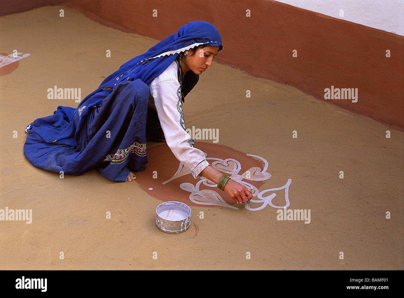 Indien, Rajasthan State, Dorf in der Nähe von Tonk, eine Frau ist auf dem Boden ihres Hauses für Silvester Malerei. Stockfoto