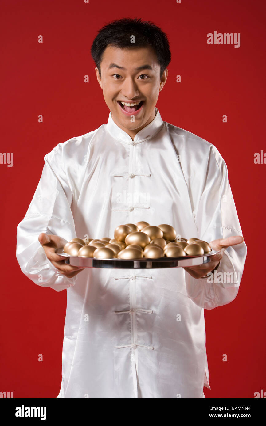 Mann mit Tablett mit goldenen Eiern Stockfoto