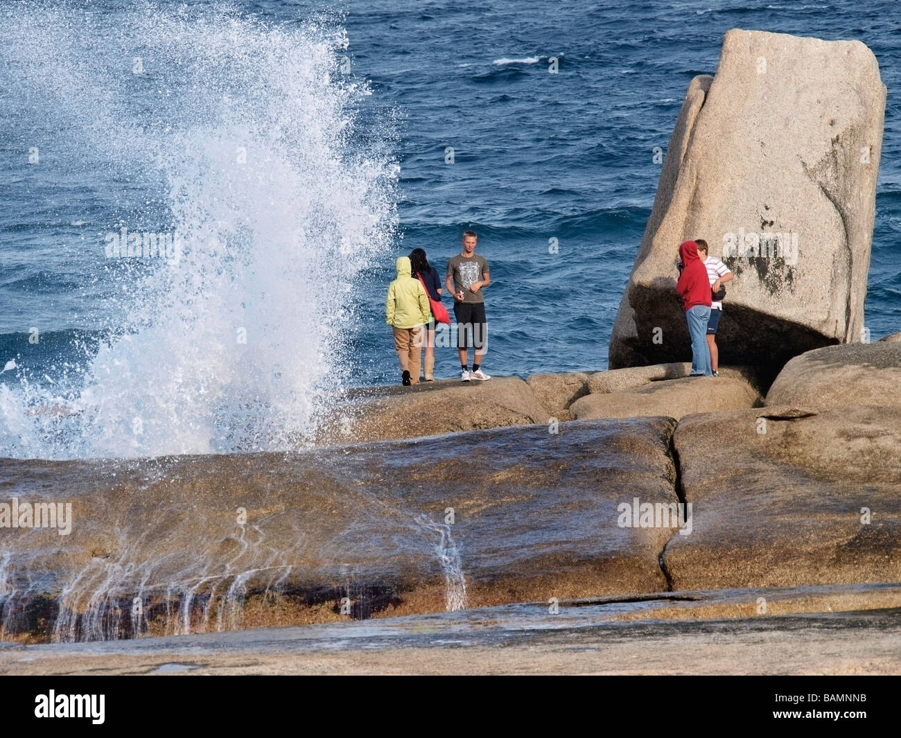 Touristen stehen und posieren für Fotos am Blowhole in Bicheno Tasmanien Australien Stockfoto