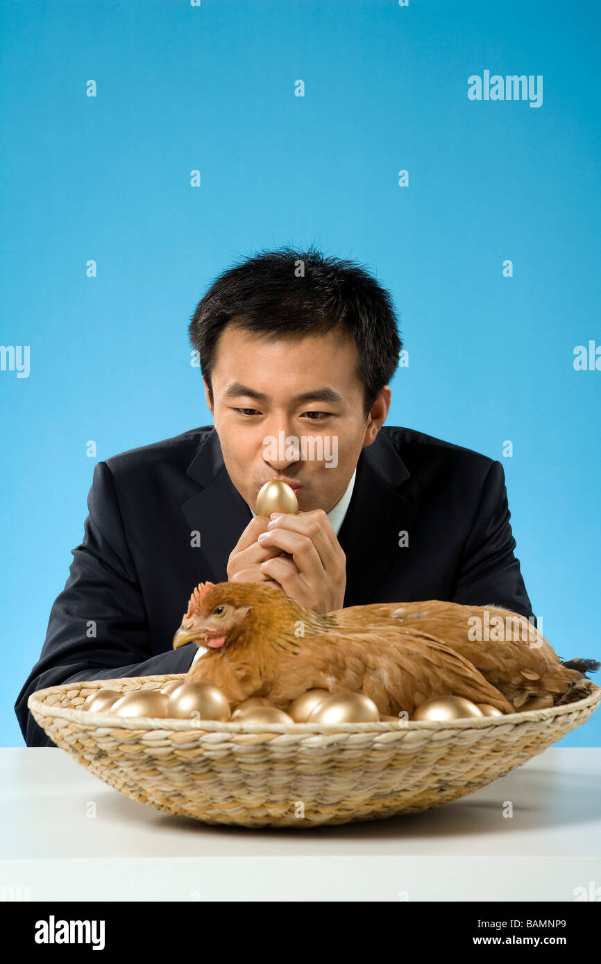 Geschäftsmann mit Huhn und goldenen Eiern Stockfoto