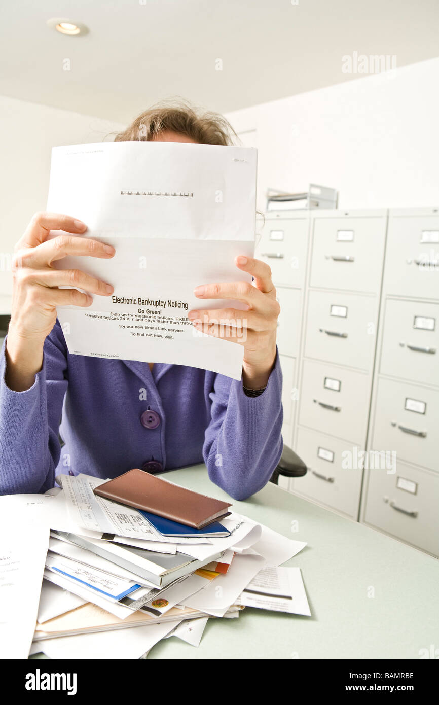 Verzweifelte Frau mit Insolvenz Bekanntmachung Stockfoto