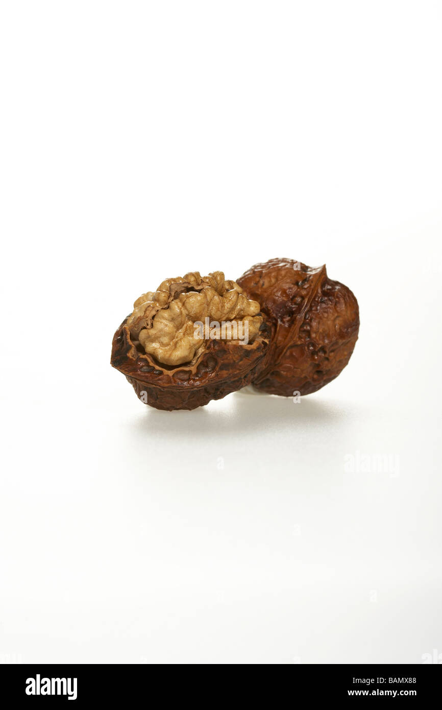 Eine geöffnete und eine ganze Walnuss Stockfoto