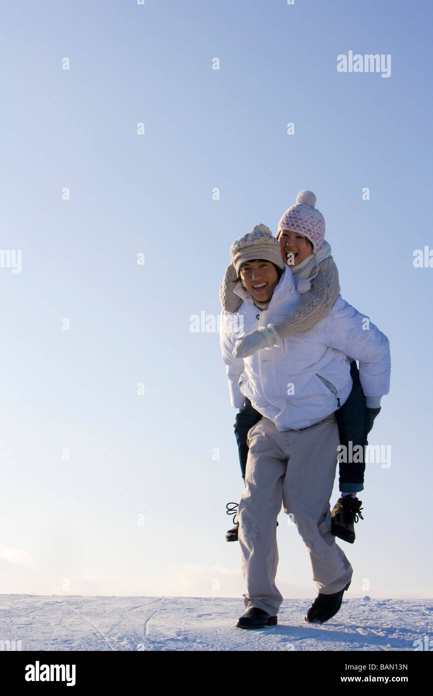 Junger Mann, eine junge Frau Huckepack tragen Stockfoto