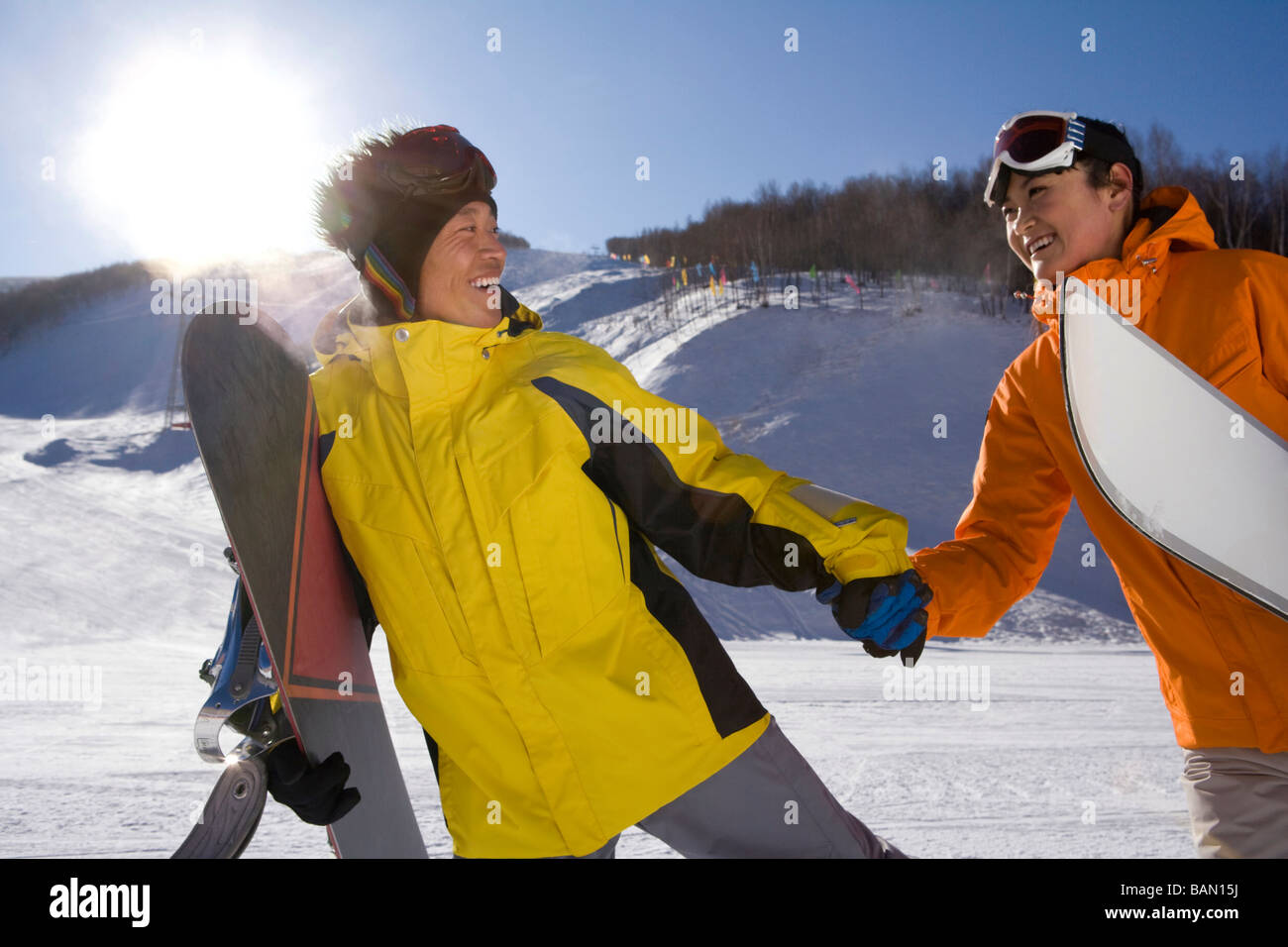 Junger Mann mit einem Snowboard Hand in Hand mit einer jungen Frau Stockfoto