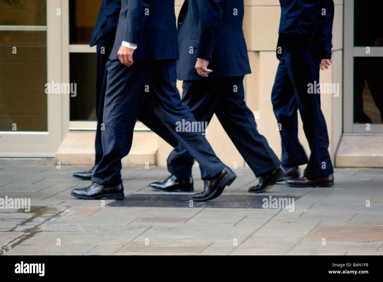 Business Männer/Banker in Business-Kleidung gehen in flottem Tempo auf einer Stadtstraße, als ein Team während eines nicht Schritt ist Stockfoto