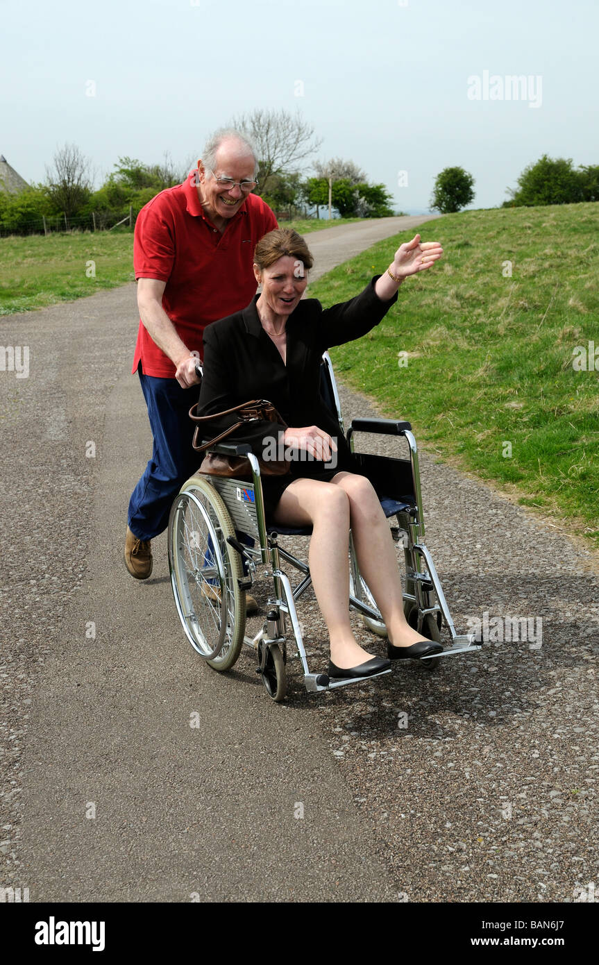 Ältere Pfleger schob Frau in einem Rollstuhl in der englischen Landschaft UK Stockfoto