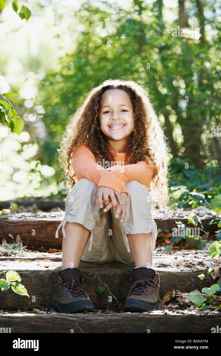 Junge afrikanische Mädchen lächelnd in Wald Stockfoto