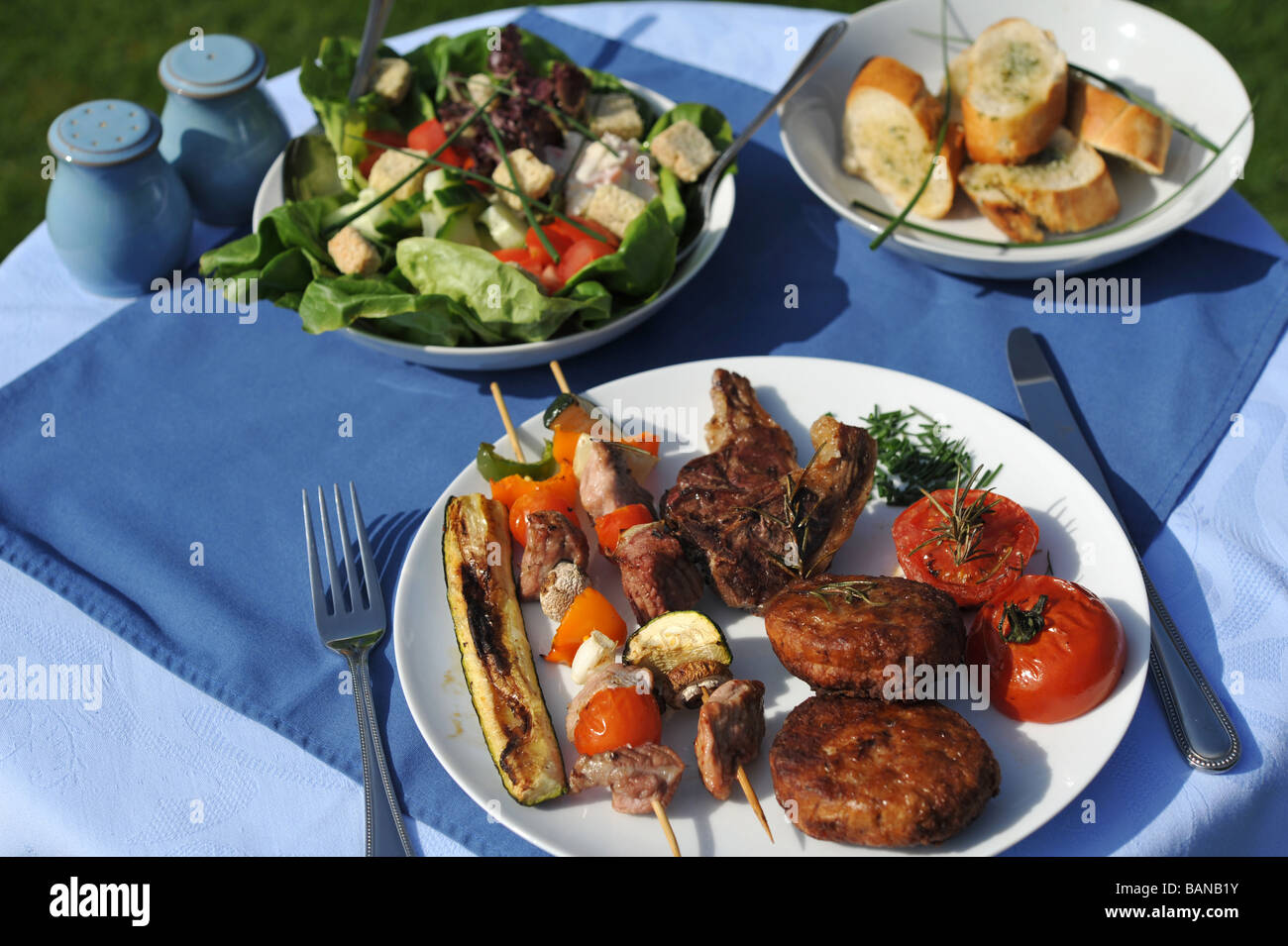 Grill-Abendessen mit Salat und Knoblauchbrot. Stockfoto