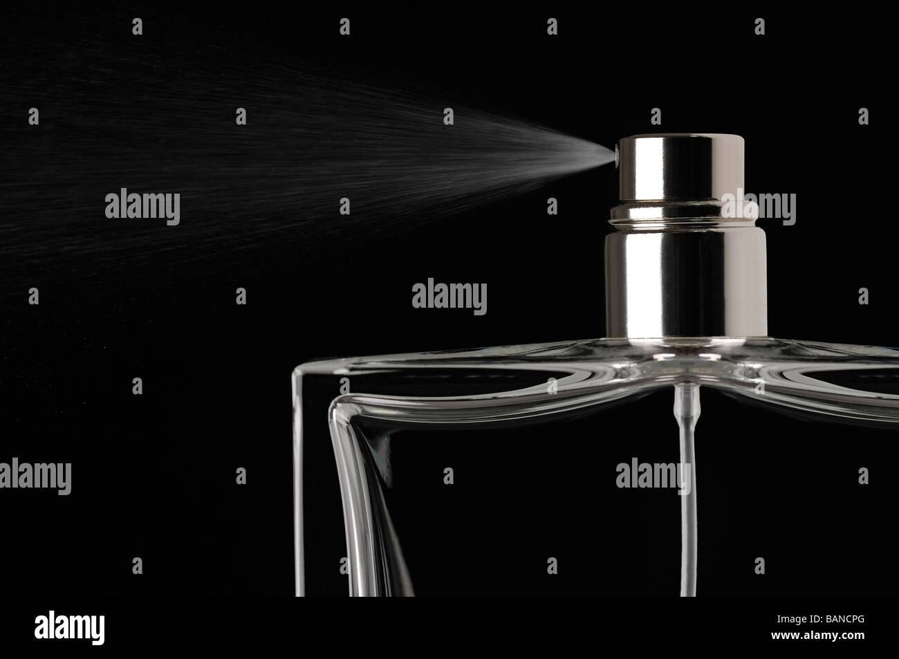 Parfüm Spray vor schwarzem Hintergrund Stockfoto