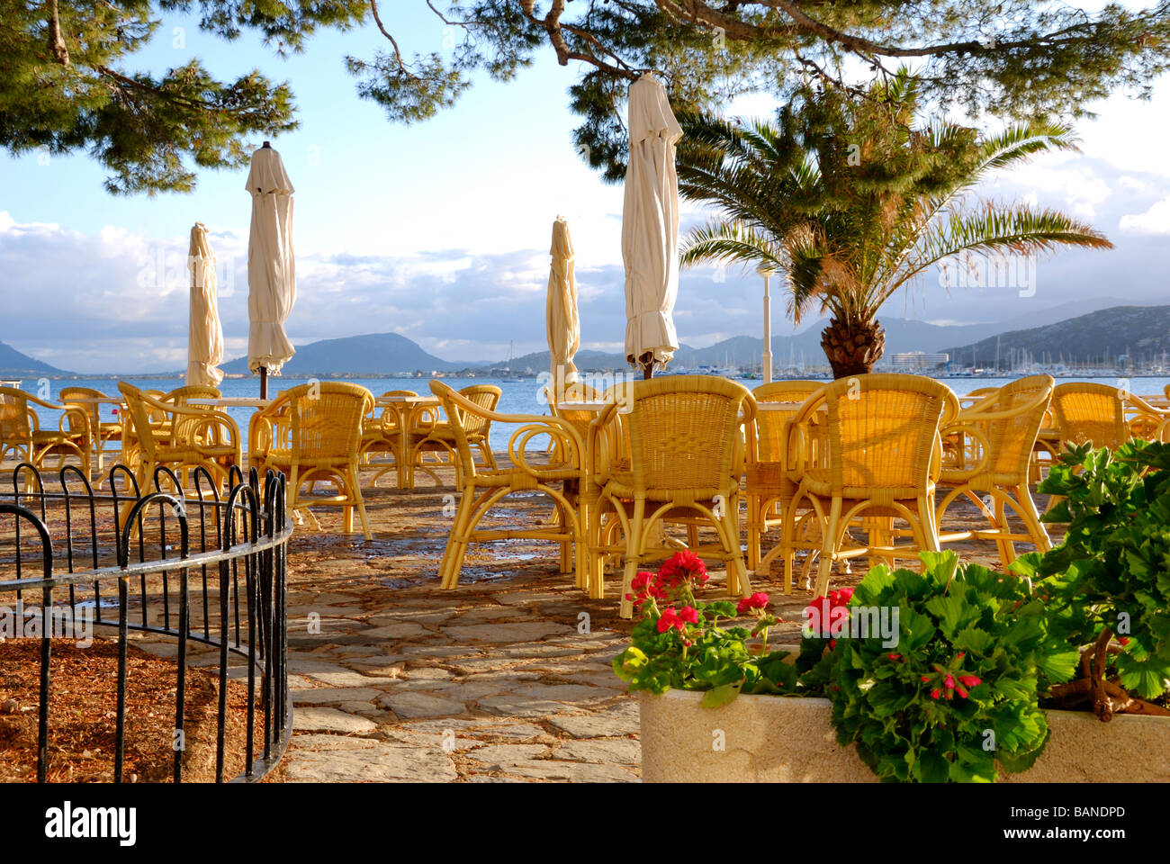 Outdoor-Hotel Illa d ' or Restaurant mit Blick auf Pollenca Bucht mit Tramuntana-Gebirge im Hintergrund Sidelit von warmen goldenen Sonnenuntergang Stockfoto
