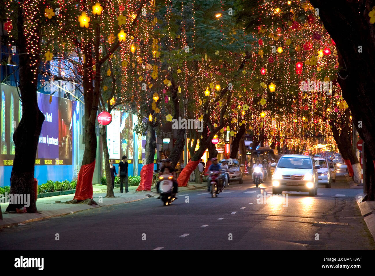 Dekorative Leuchten hängen von den Bäumen an Dong Khoi street in der Feier des Tet Lunar New Year in Ho-Chi-Minh-Stadt-Vietnam Stockfoto