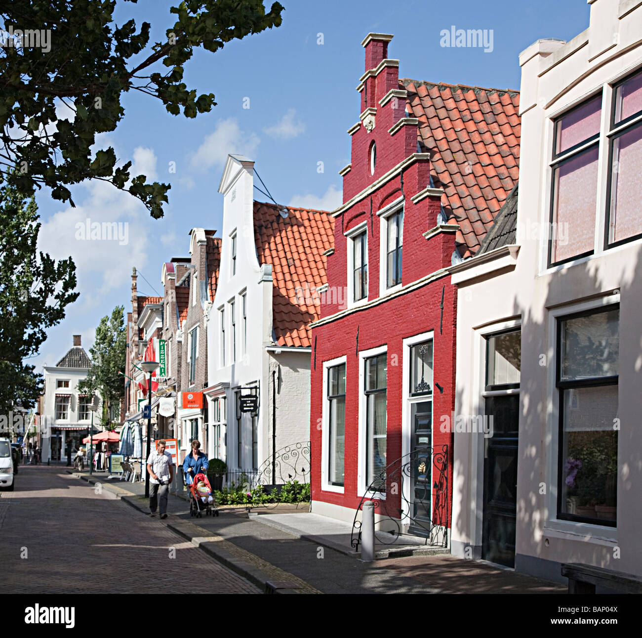 Passanten in der Straße von Giebelhäusern und Geschäften Harlingen Friesland Niederlande Stockfoto