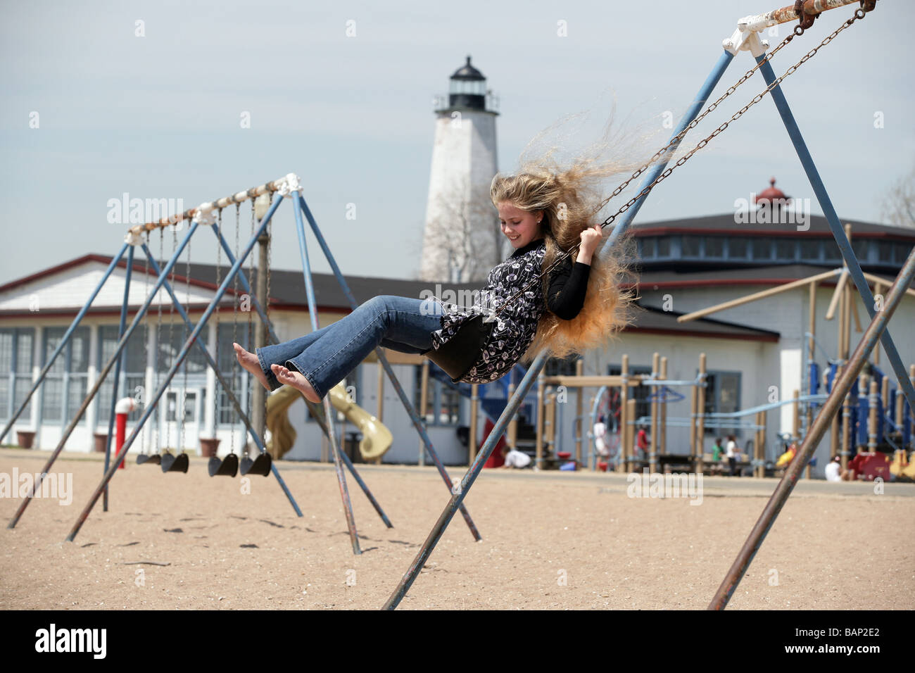 Ein junges Mädchen schwingt auf einer Schaukel am Lighthouse Point Park in New Haven Connecticut Stockfoto