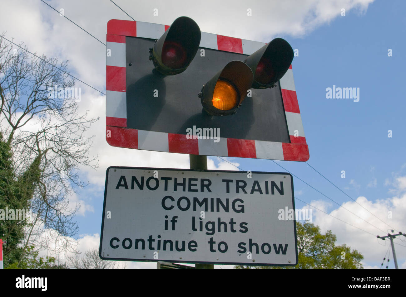 Bernstein-Warnleuchten blinken bei einem Bahnübergang Stockfoto