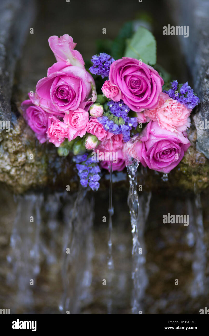 Rosen an einem Brunnen während der Bisley gut kleiden custom bei Bisley, Gloucestershire platziert. Stockfoto
