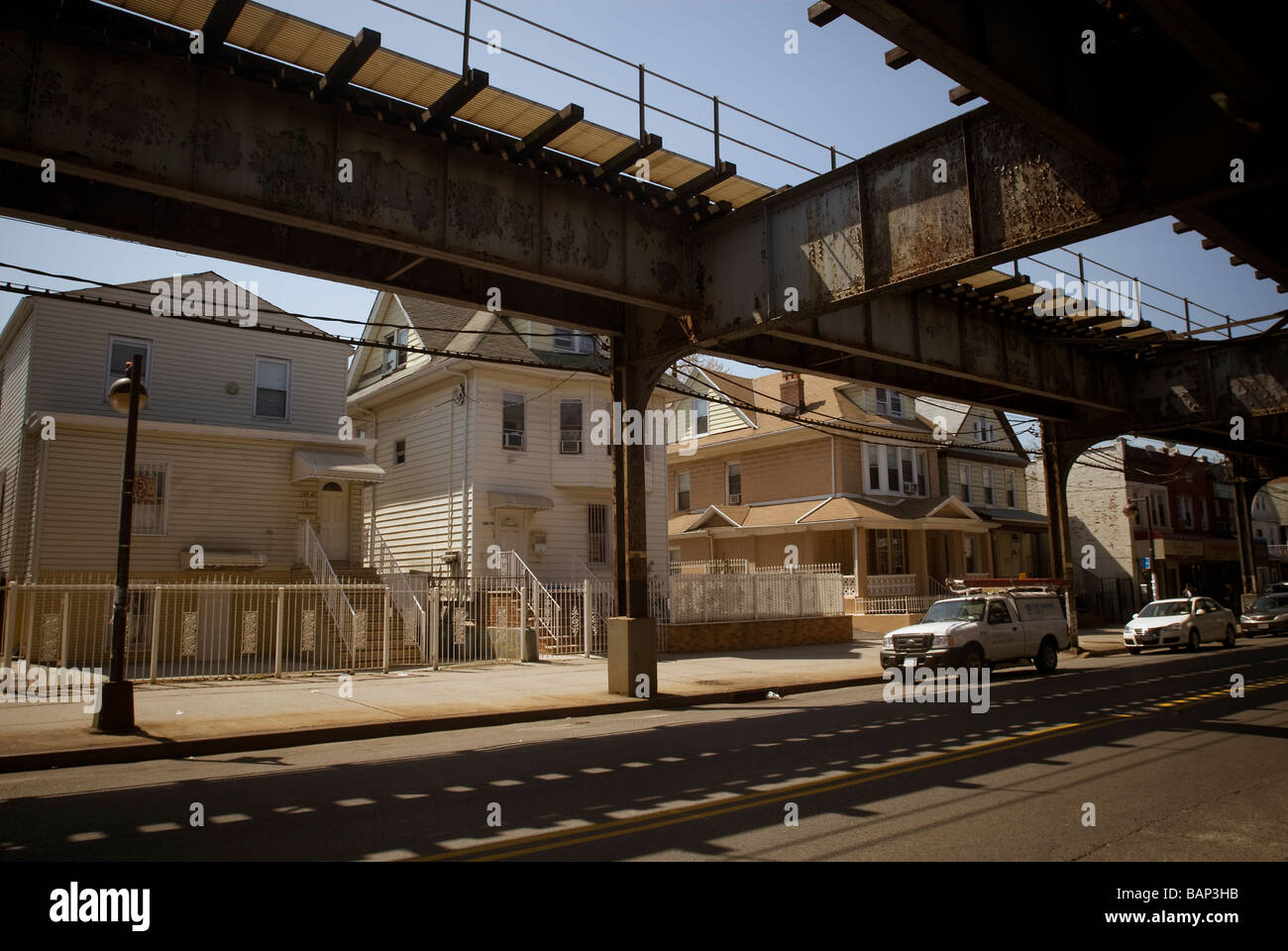 Einfamilienhäuser an der Roosevelt Avenue befindet sich unter der erhöhten Zahl 7 Flushing-u-Bahnlinie in Corona, Queens, New York Stockfoto