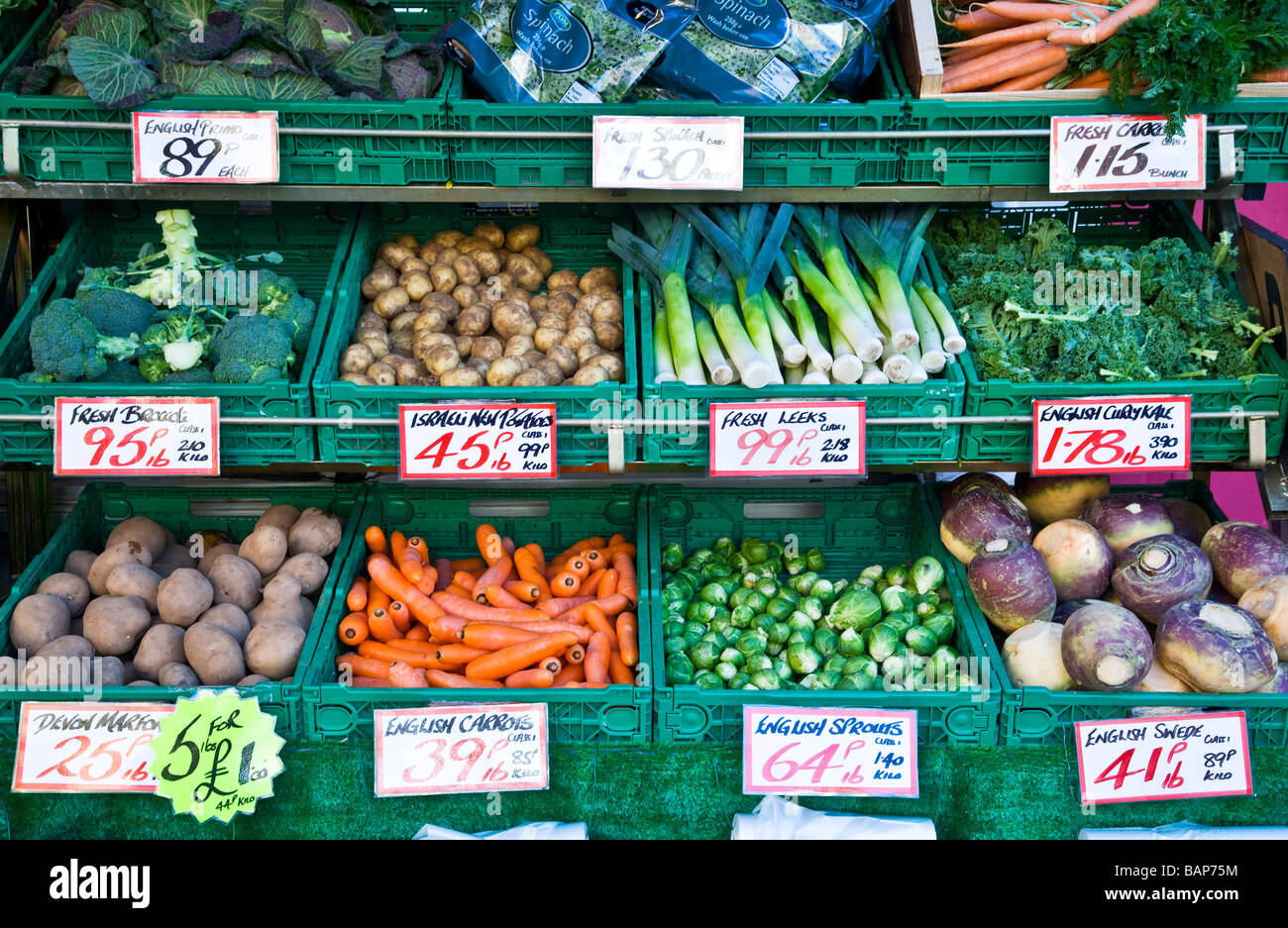 Gemischtes frisches Gemüse in gestuften Anzeige außerhalb ein Gemüsehändler Shop oder Store in England UK Stockfoto
