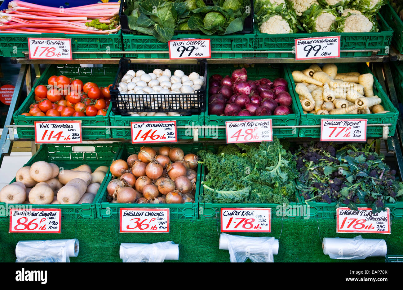 Gemischtes frisches Gemüse in gestuften Anzeige außerhalb ein Gemüsehändler Shop oder Store in England UK Stockfoto
