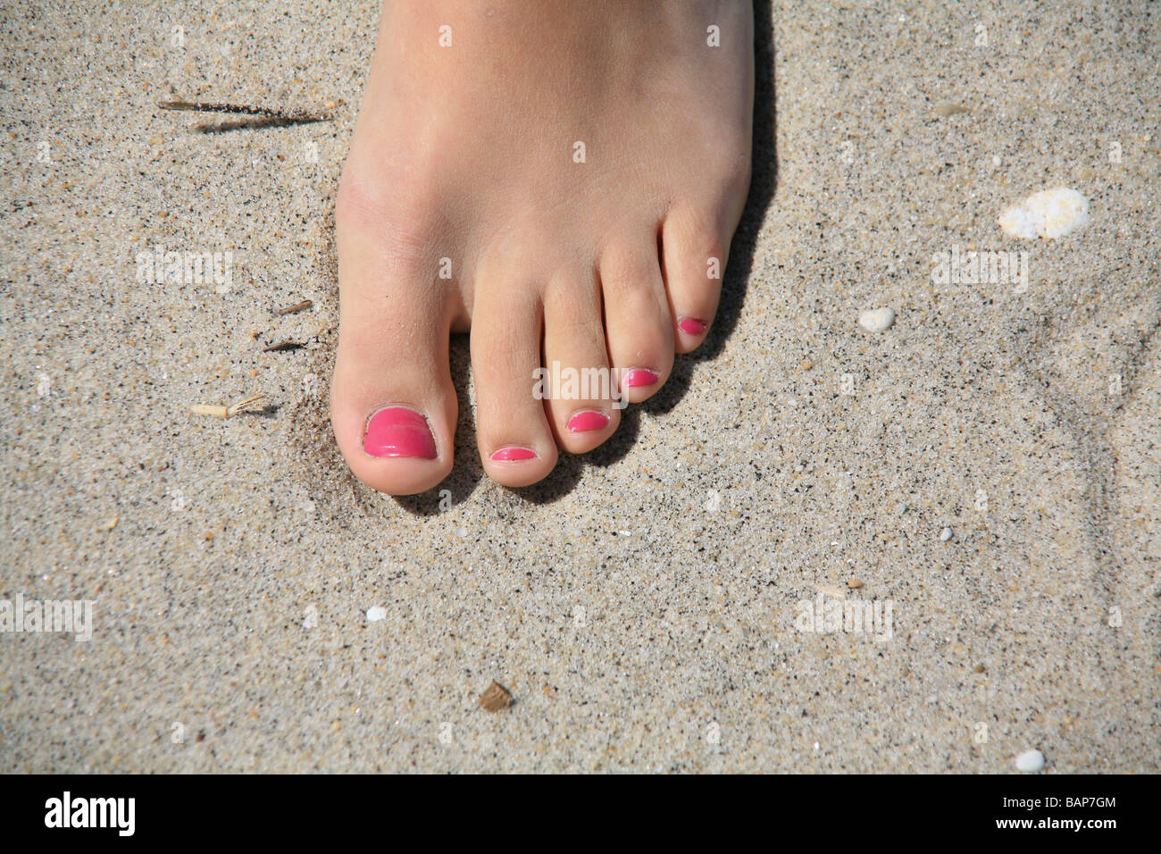 Lackierten Fußnägel an einem Sandstrand Stockfoto