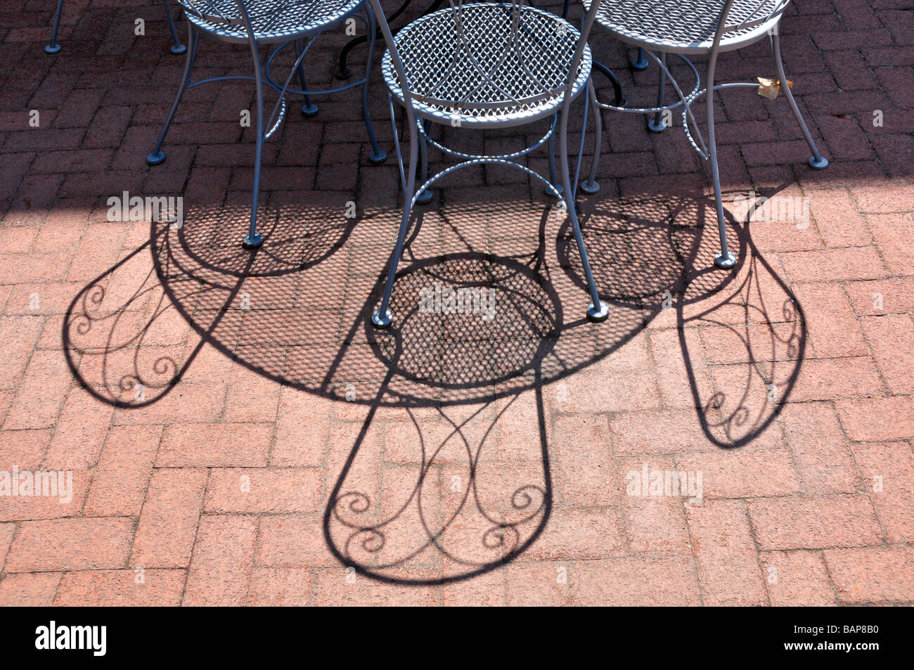 Metall Chairson rote Ziegel bilden interessante Schatten. Stockfoto