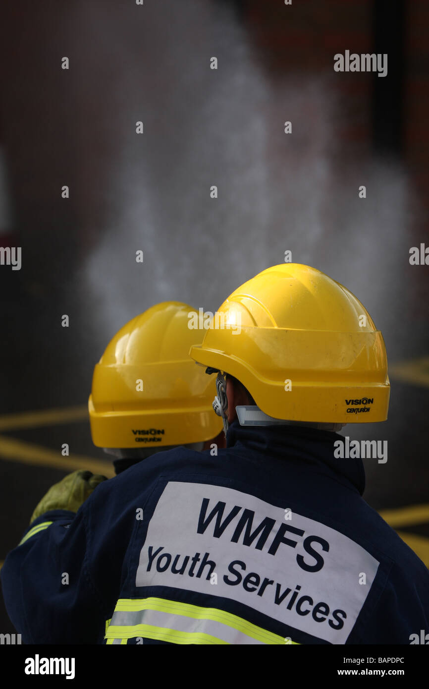 Zwei junge Menschen aus den West Midlands Fire Service Youth Services Gruppe Teilnahme an eine Brandschutzübung in England Stockfoto