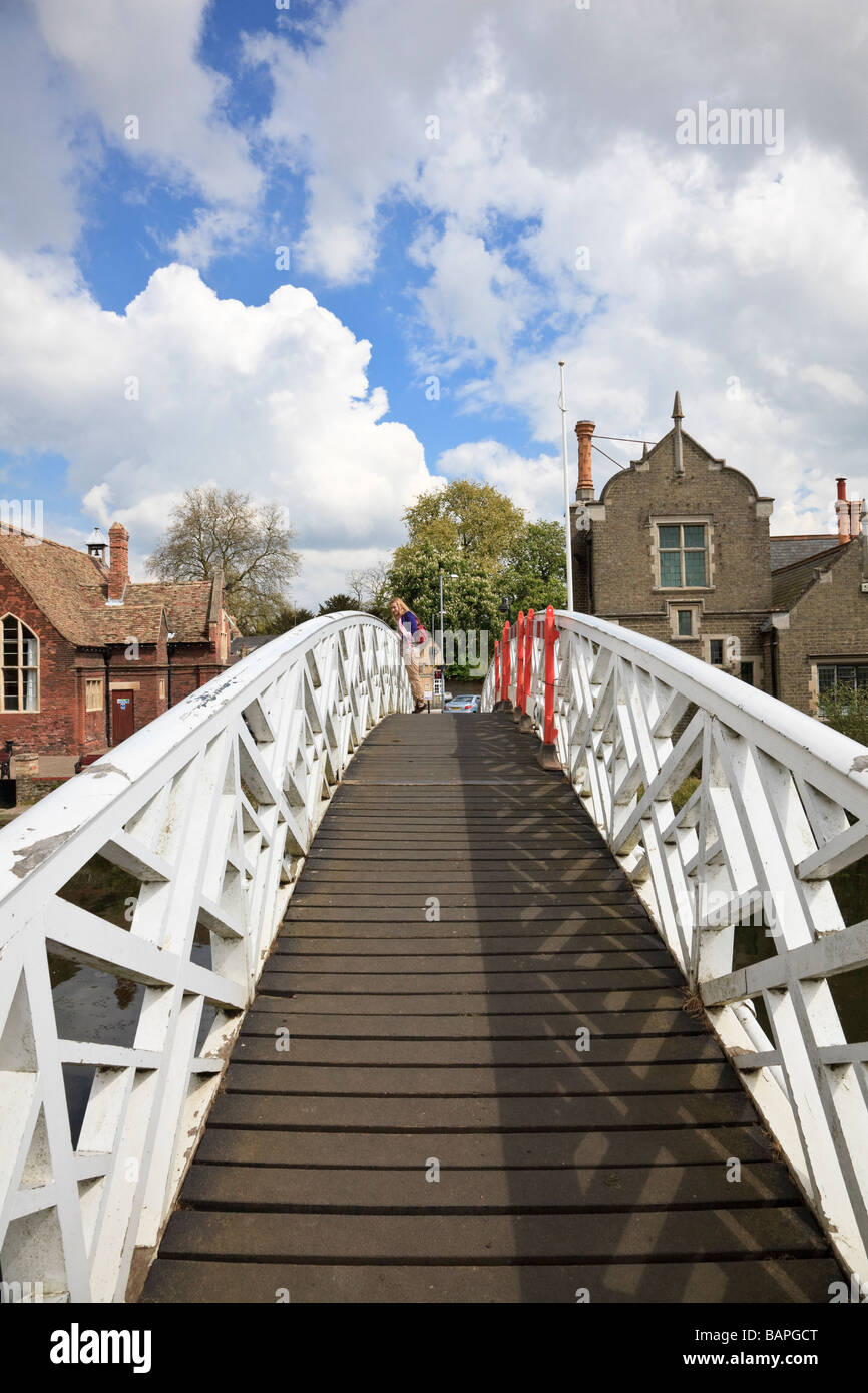 Frau stand auf Zehenspitzen mit Blick auf die gewölbte Holzsteg auf den Fluss Great Ouse in Godmanchester Cambridgeshire UK Stockfoto