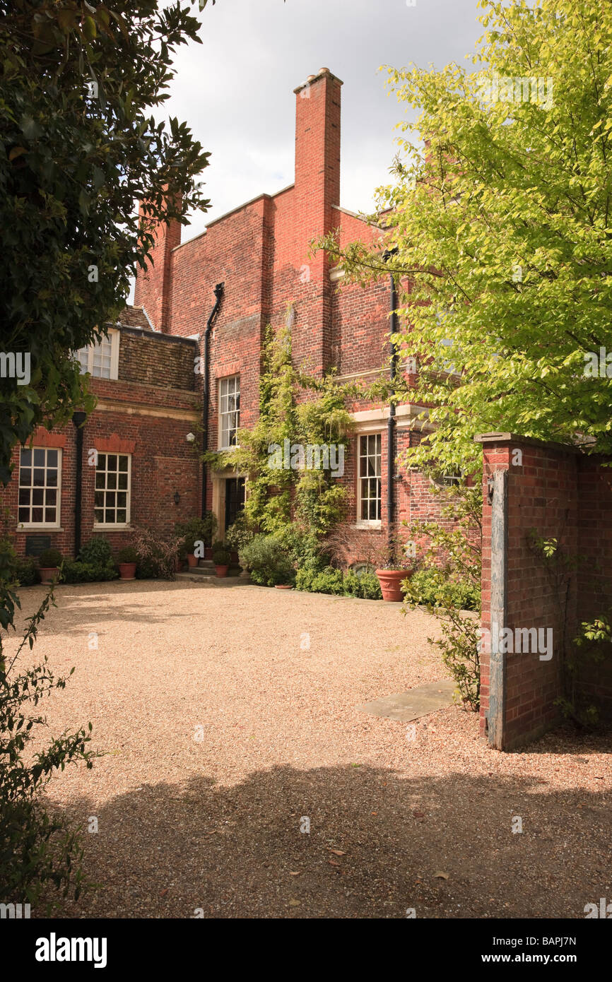 Attraktive sonnenbeschienenen Kies Hof und kletternden Pflanzen und Töpfe auf dem Gelände eines Flügels Haus Godmanchester "Cambridgeshire UK Stockfoto