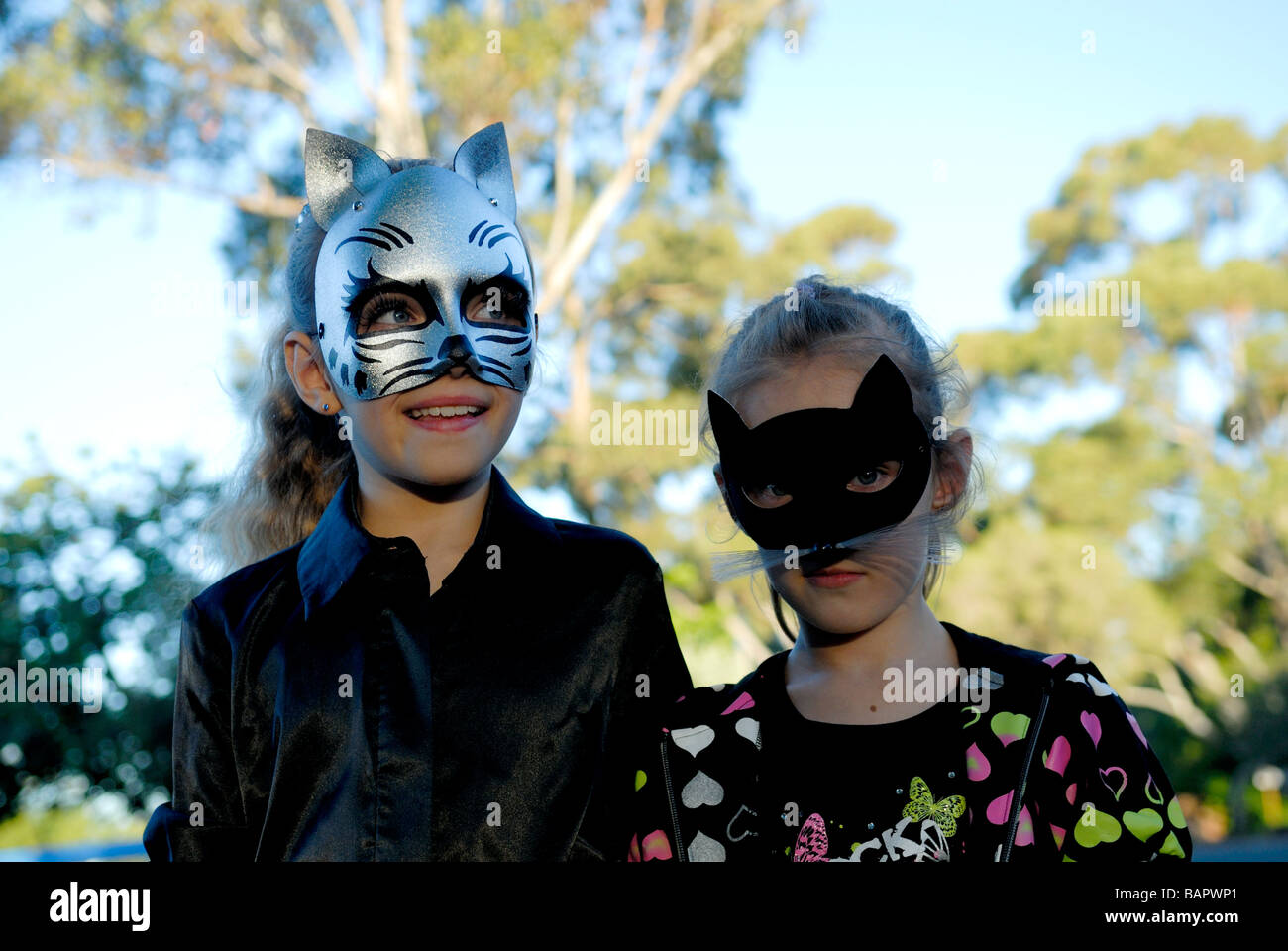 Zwei Schwestern 10 Jahre 7 Jahre alt tragen Katze Masken Stockfoto