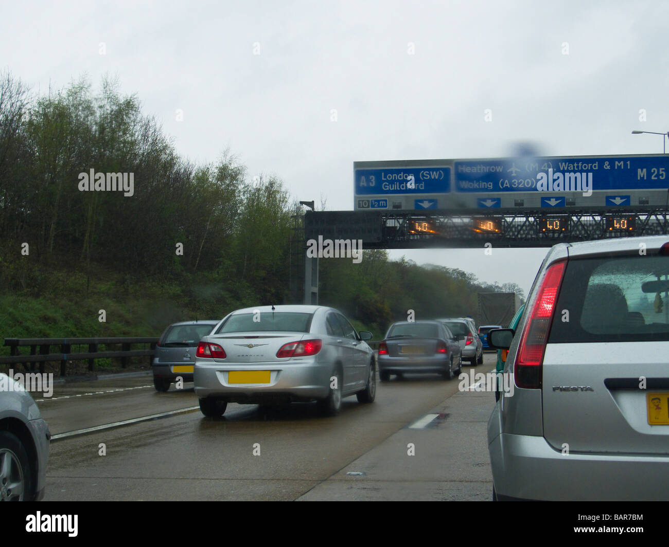 Warteschlangen Verkehr auf der Autobahn M25 in nassen Wetter, England Stockfoto