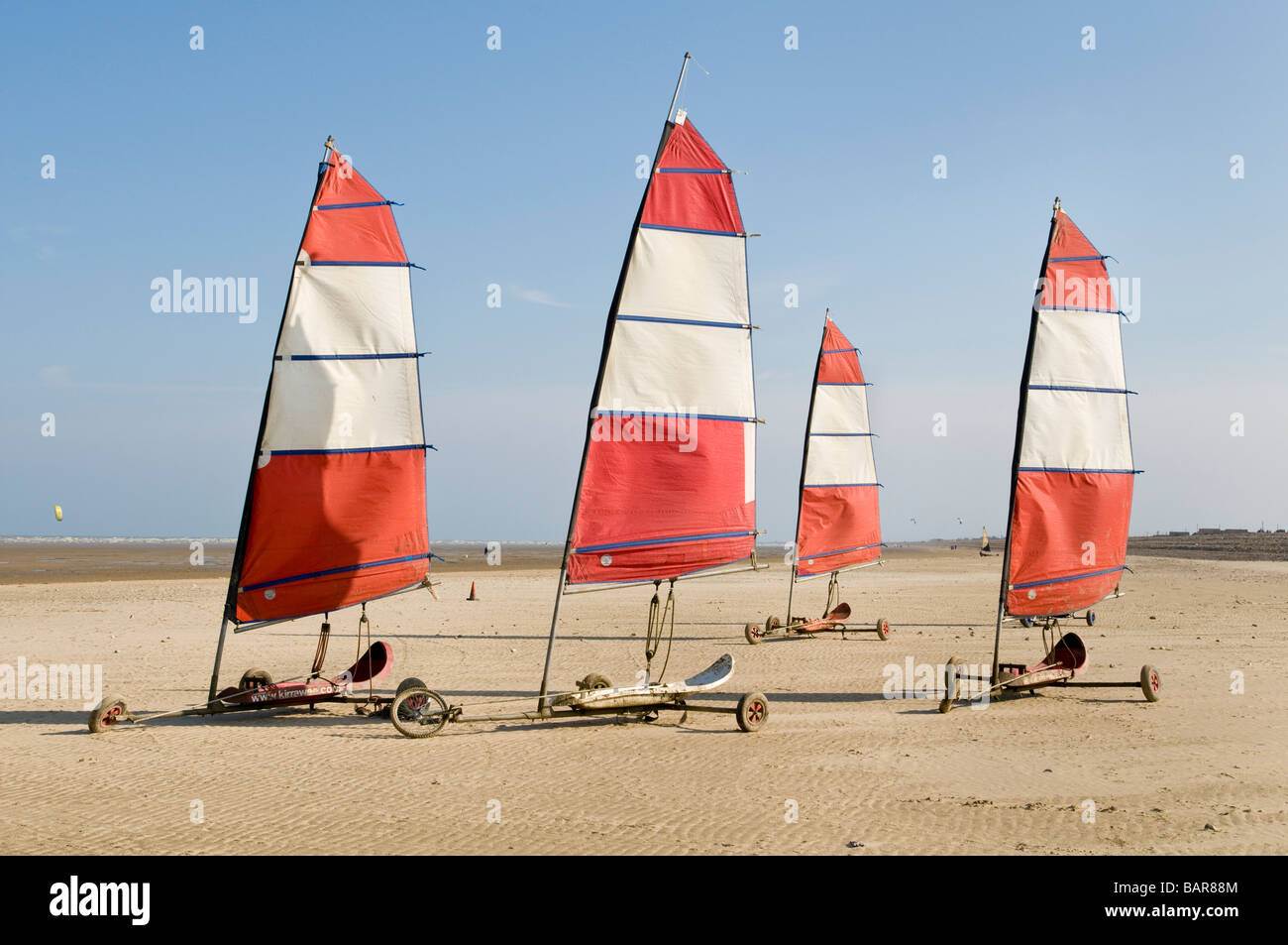 Vier Land-Yachten sitzen an einem Strand am Ende von einem Sommertag Stockfoto