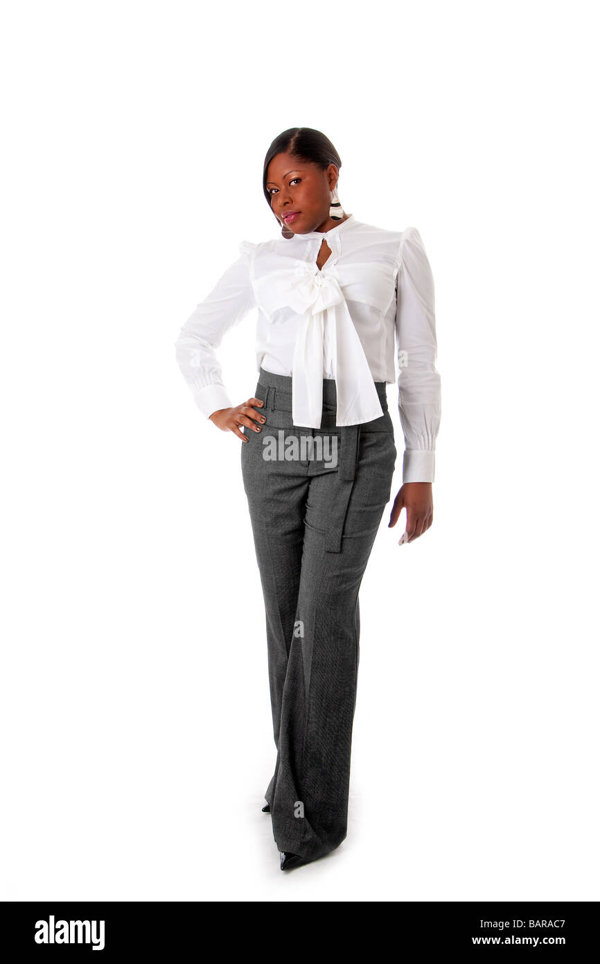 Schöne afrikanische amerikanische Geschäftsfrau mit Haltung gekleidet in ein weißes Hemd und graue Hose stehend Hände an Hüfte isoliert Stockfoto