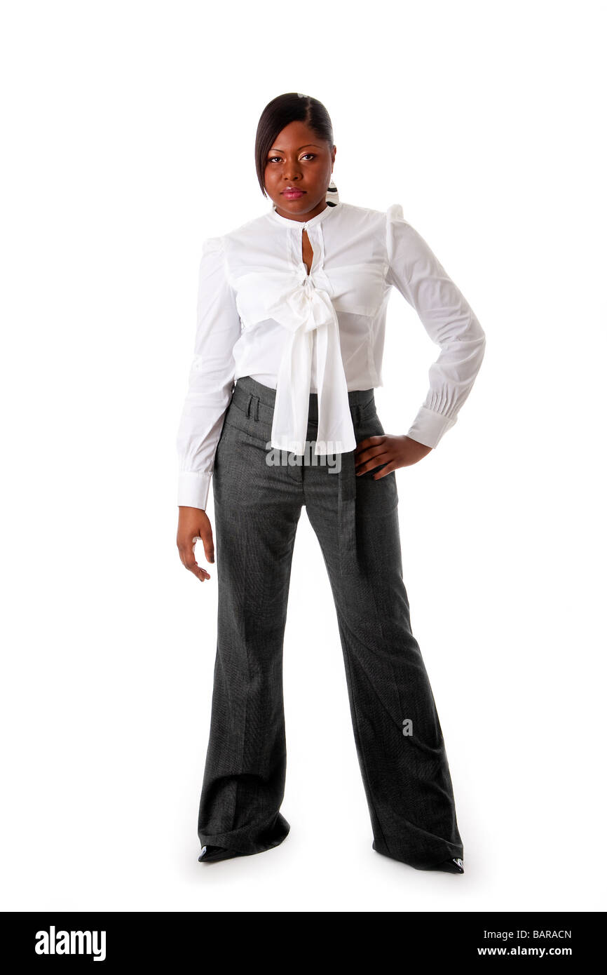 Schöne afrikanische amerikanische Geschäftsfrau mit harten Haltung gekleidet in ein weißes Hemd und graue Hosen stehen isoliert Stockfoto