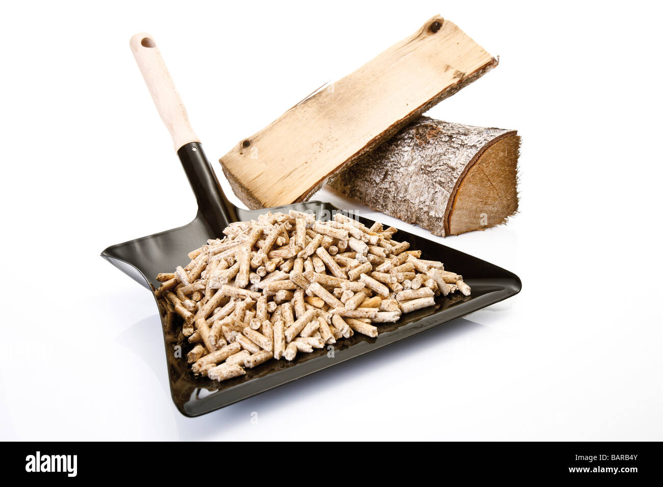 Holzpellets auf Kehrschaufel und Protokolle, close-up Stockfoto