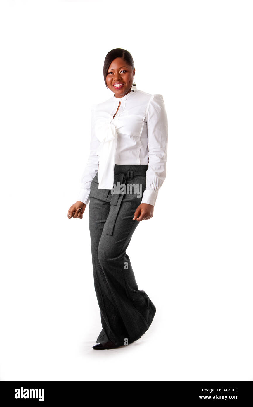 Schöne afrikanische amerikanische Geschäftsfrau mit Haltung, gekleidet in ein weißes Hemd und graue Hose, die isoliert stehenden tanzen glücklich Stockfoto