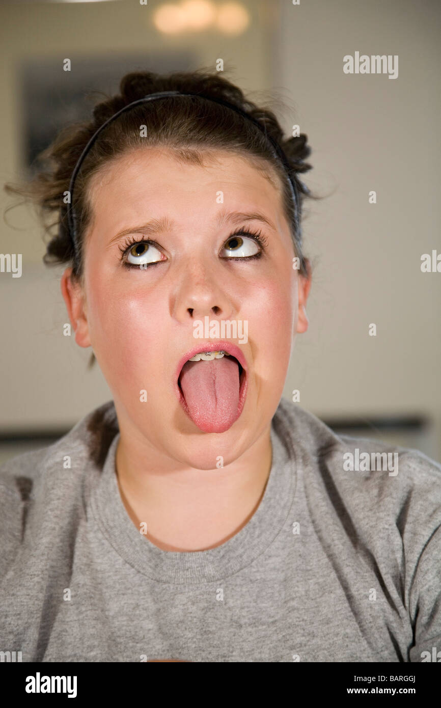 Ein ziemlich junges Mädchen sagen Ahhh in einer Arztpraxis s tragen Zahnspangen und und zeigt ihre Zunge Stockfoto
