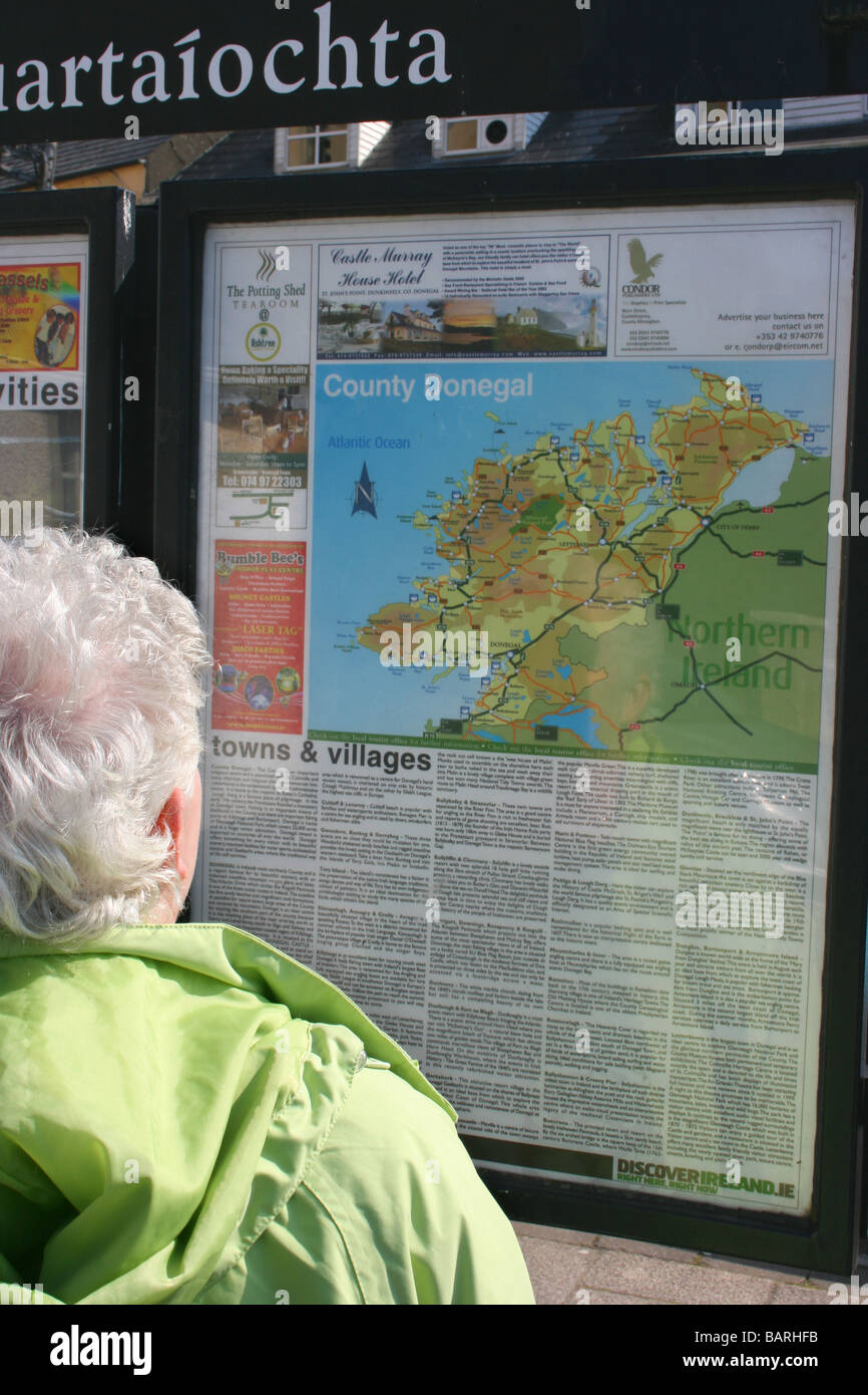 Frau touristischen lesen Informationstafel und Karte der Grafschaft Donegal in Donegal Town, Irland Stockfoto